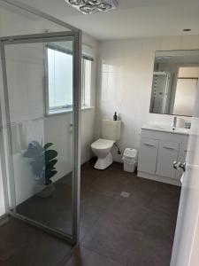 a bathroom with a shower and a toilet and a sink at Bella Vita Beach House in Robe +5 photos