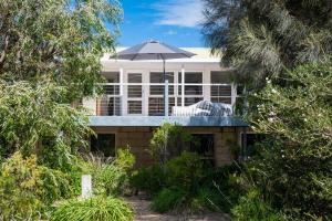 a house with an umbrella on top of it at Bella Vita Beach House in Robe