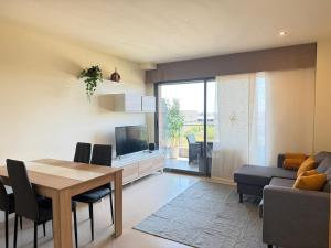 a living room with a dining room table and a television at Apartment in Castelldefels! in Castelldefels