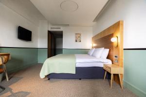 pokój hotelowy z łóżkiem i telewizorem w obiekcie The Alan w Manchesterze
