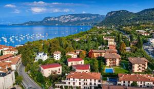 a town on the shore of a lake with boats at Mari&Monti Apartment in Bardolino
