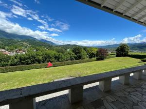 a bench with a view of a grassy field at Mini Amina in Feltre