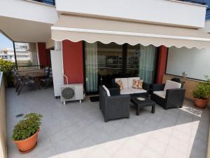 a patio with couches and a table and chairs at Blue Horizon SKG in Thessaloniki