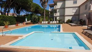 a swimming pool in front of a building at Casa Lesarlo - T3 luxury, garden, pool - Praia D'El Rey in Casal da Lagoa Seca