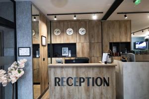 a restaurant with a reception desk and clocks on the wall at Philippopolis Hotel in Plovdiv