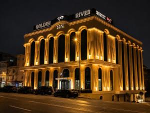 a lit up building on a city street at night at Golden River Hotel By Continent in Arnavutköy