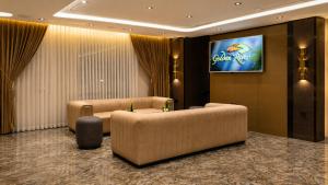a hotel lobby with two couches and a television at Golden River Hotel By Continent in Arnavutköy