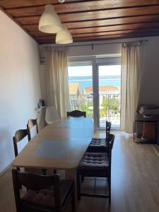 a dining room table and chairs with a view of the ocean at Dramalj apartman 4+1 in Dramalj