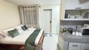 a small bedroom with a bed and a microwave at Wattle Residence Ngong in Ngong +8 photos