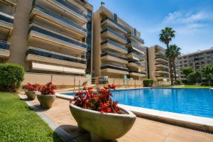 a building with a swimming pool and some flowers at Ventura Park CC3 in Salou