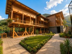 a large wooden house with a porch and a patio at Buneba Resort in Borçka