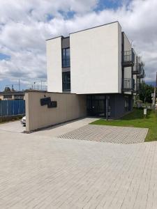 a large white building on top of a parking lot at Penzión Alma in Poprad