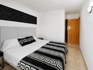 a bedroom with a bed with black and white blankets at Ventura Park CC3 in Salou +8 photos