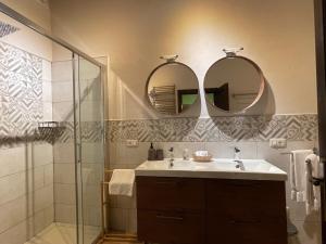 a bathroom with a sink and two mirrors at Villa Rigacci in Reggello