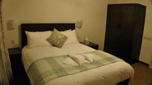 a bedroom with a bed with two towels on it at Bay Lodge in Birchington