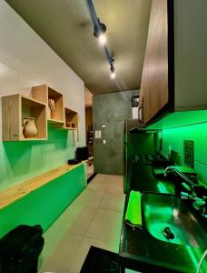 a green kitchen with a sink and a counter at Reserva 1202 - Hospedagem in Cabedelo