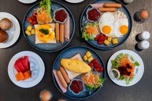 a table with four plates of breakfast foods at Oakwood Studios Sukhumvit Bangkok in Bangkok
