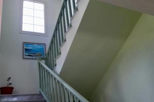 a stairwell with a green and white wall and a window at Orama Hotel in Sígrion