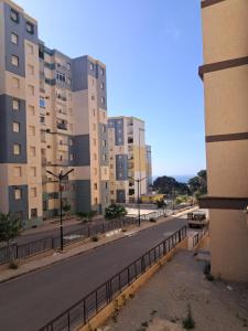 a city street with tall buildings and a road at Nesma Douaouda in Douaouda