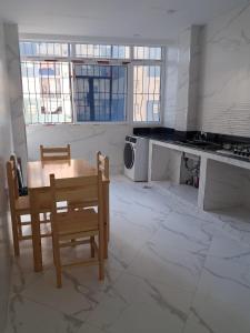 a kitchen with a table and chairs and windows at Nesma Douaouda in Douaouda