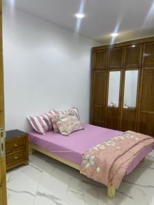 a bedroom with a purple bed and a wooden cabinet at Nesma Douaouda in Douaouda
