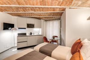 a hotel room with two beds and a kitchen at Residenze Piazza Dante in Naples