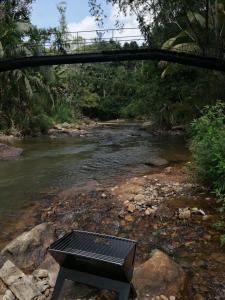a black picnic table sitting next to a river at Miracle holiday homestay in Demodera