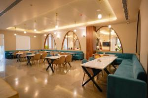 a restaurant with tables and couches and chairs at Barsana Hotel & Resorts in Jaipur