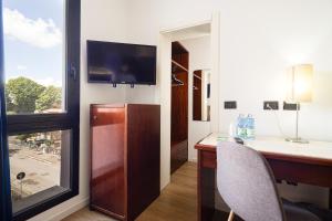 a room with a desk and a tv on a wall at Hotel Sirena & Cucina in Cesenatico