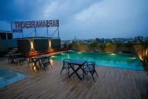 a patio with chairs and a swimming pool at night at Barsana Hotel & Resorts in Jaipur