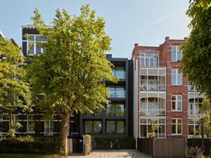 an apartment building with a tree in front of it at Numa Amsterdam Vondelpark in Amsterdam +17 photos
