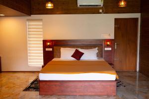 a bedroom with a large bed in a room at West Bay Palm Tree Beach Resort in Varkala