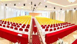 an empty banquet hall with red and white chairs at Quê Tôi Hotel in Soc Trang