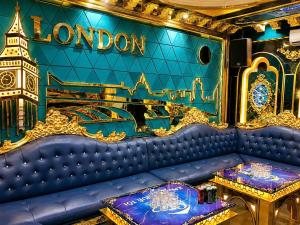 a blue couch in a room with a clock tower at Quê Tôi Hotel in Soc Trang
