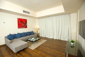 a living room with a couch and a table at Al Manzil Hotel Bahrain in Juffair