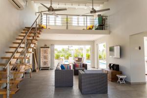 a living room with a staircase and a couch at Malmok Beach Break Villa in Palm-Eagle Beach