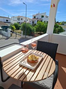 a table with two glasses of wine on a balcony at Casa Svancy in Lagoa