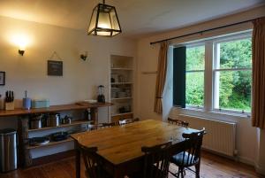 a dining room with a wooden table and a window at Torridon Estate B&B Rooms and Self catering Holiday Cottages in Torridon