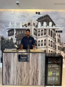 a man standing at a counter in front of a building at ايا ان AYA Inn in Jeddah