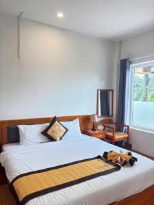 a bedroom with a large bed with a bow on it at Cherry Luxury Hotel in Da Lat
