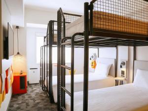 a room with two bunk beds and a desk at ibis Styles Tokyo Bay in Urayasu