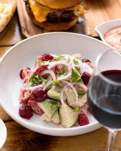 a white plate with a salad and a glass of wine at Planet kazbegi in Kazbegi