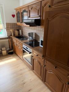 a kitchen with wooden cabinets and a stove top oven at Roxy in Beverungen
