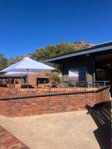 a brick wall with an umbrella and a building at Wonderwerk cave adventures in Kuruman