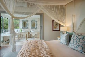 a bedroom with a large bed and a bathroom at Tintswalo Atlantic in Hout Bay