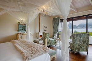 a bedroom with a bed with a white canopy at Tintswalo Atlantic in Hout Bay
