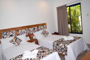 a hotel room with two beds and a window at Hotel Jungle House in Iquitos