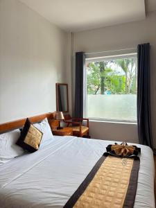 a bedroom with a bed with a large window at Cherry Luxury Hotel in Da Lat +16 photos