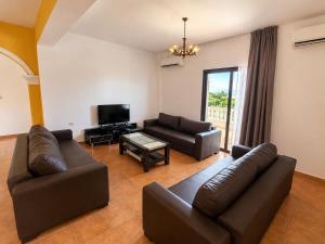 a living room with a couch and a tv at Villa Lions in Ksamil