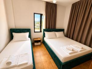 two beds in a small room with curtains at Villa Lions in Ksamil